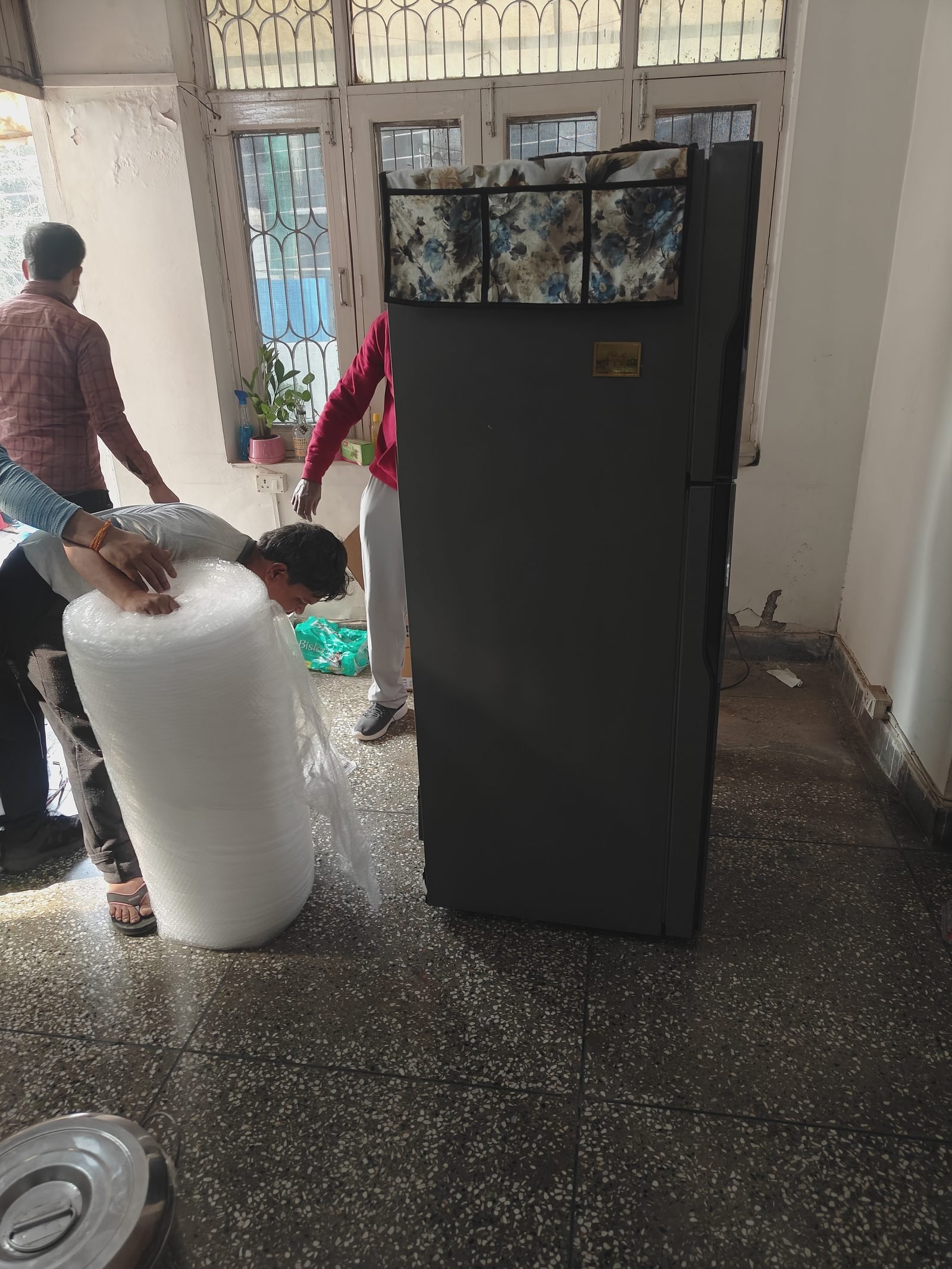 Bubble wrap rolls kept ready beside a fridge being prepared for a move