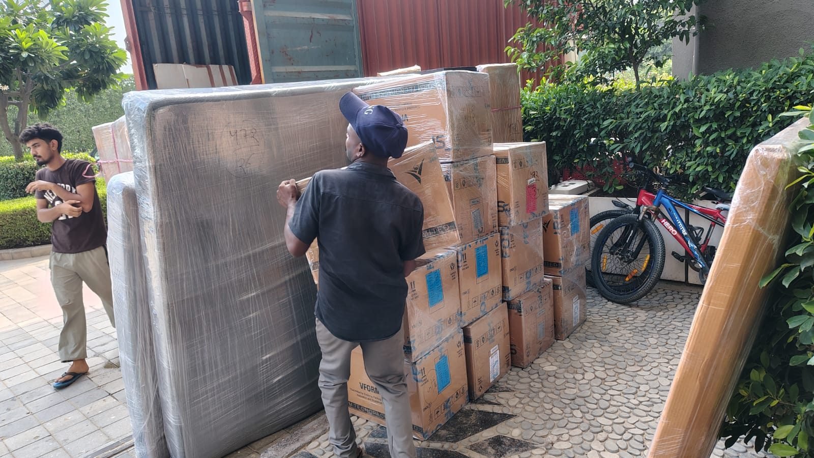 Movers carrying a packed, wrapped item during a relocation